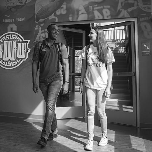 two students walking inside the darrell gooden building